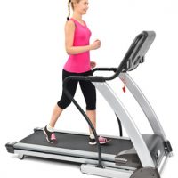 young woman doing exercises on treadmill, on white background